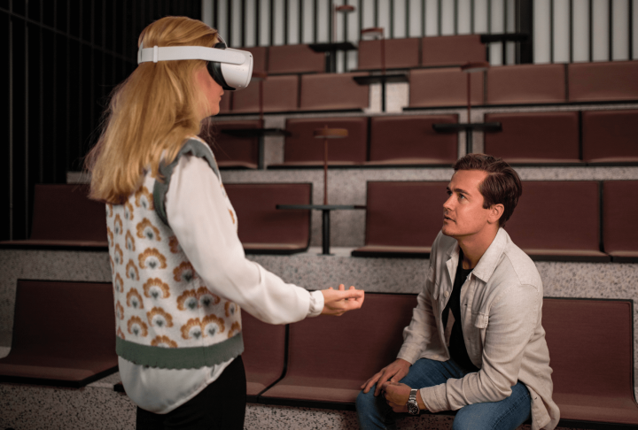 kvinna med VR-headset presenterar framför man